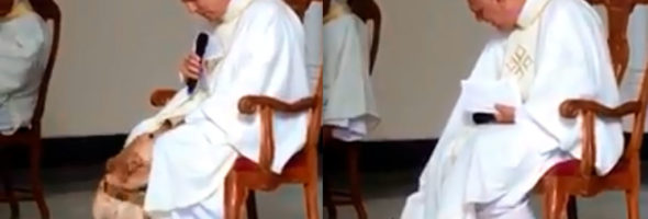 Perro juega con el sacerdote mientras está en misa